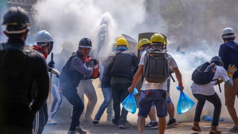 Anti-coup protesters use fire extinguishers to reduce the impact of tear gas fired by riot police in Yangon, Myanmar, on March 9.