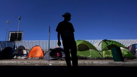 A migrant from Honduras seeking asylum in the US stands near rows of tents at the border crossing on March 1, 2021, in Tijuana, Mexico.