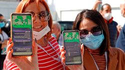Attendees show off their "green passes" (proof of being fully vaccinated against COVID-19 coronavirus disease) as they arrive at Bloomfield Stadium in the Israeli Mediterranean coastal city of Tel Aviv on March 5, 2021, before attending a "green pass concert" for vaccinated seniors, organised by the Tel Aviv municipality. - Israel took a step towards normalcy on Sunday, re-opening a raft of businesses and services from pandemic lockdowns, but with some only available to fully vaccinated "green pass" holders. Nearly three million people, almost a third of Israel's population, have received the two recommended doses of the Pfizer/BioNTech coronavirus vaccine, the world's quickest inoculation pace per capita. (Photo by JACK GUEZ / AFP) (Photo by JACK GUEZ/AFP via Getty Images)