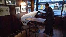 A worker wearing a protective mask puts down a table cloth inside John's Grill restaurant in San Francisco, California, U.S., on Tuesday, March 9, 2021. San Francisco Mayor London Breed said indoor dining, movie theaters and gyms can reopen on a limited basis after California moved the region to a less-restrictive tier. Photographer: David Paul Morris/Bloomberg via Getty Images