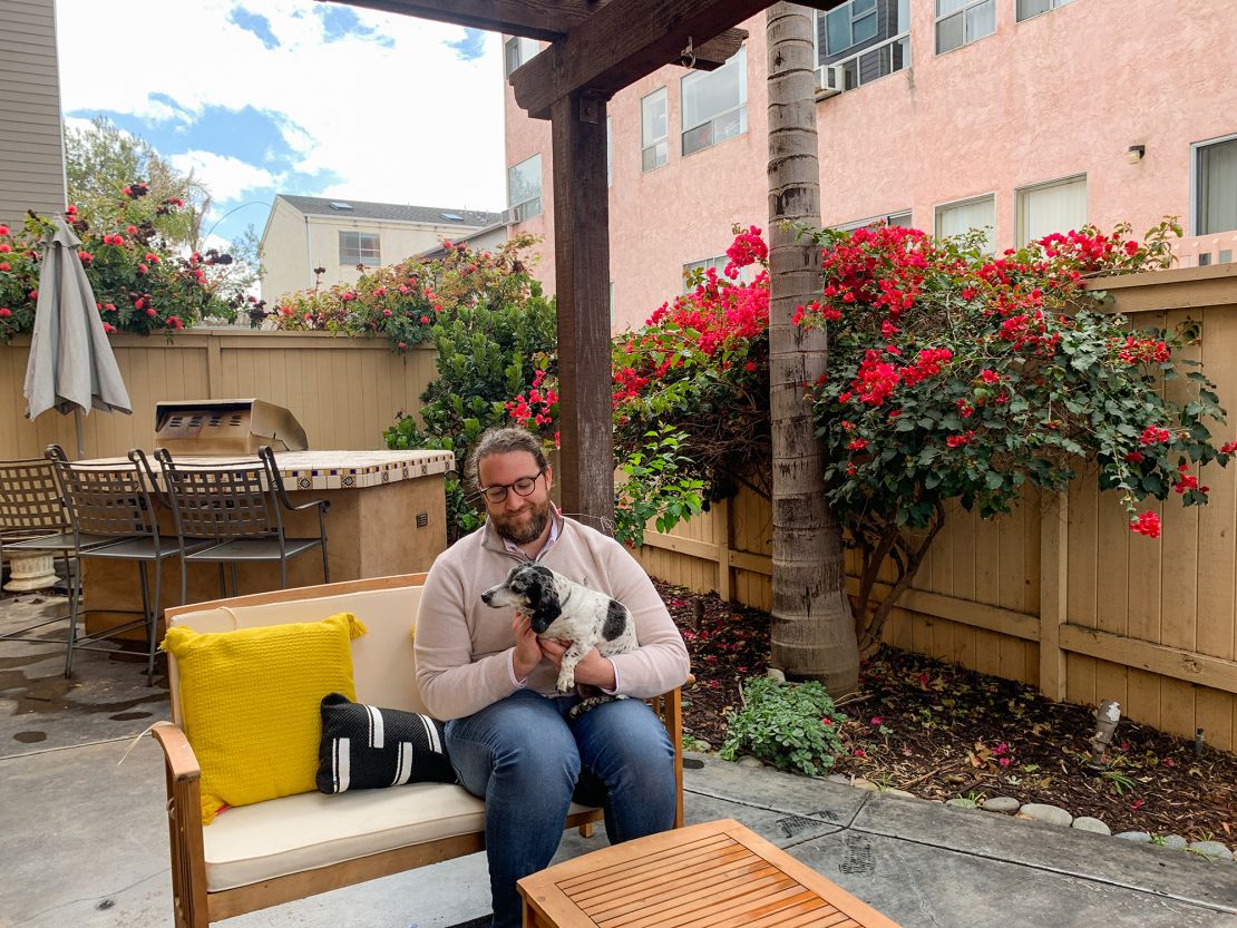 Ryan Mattison holds his roommate's dog in his new home in San Diego.