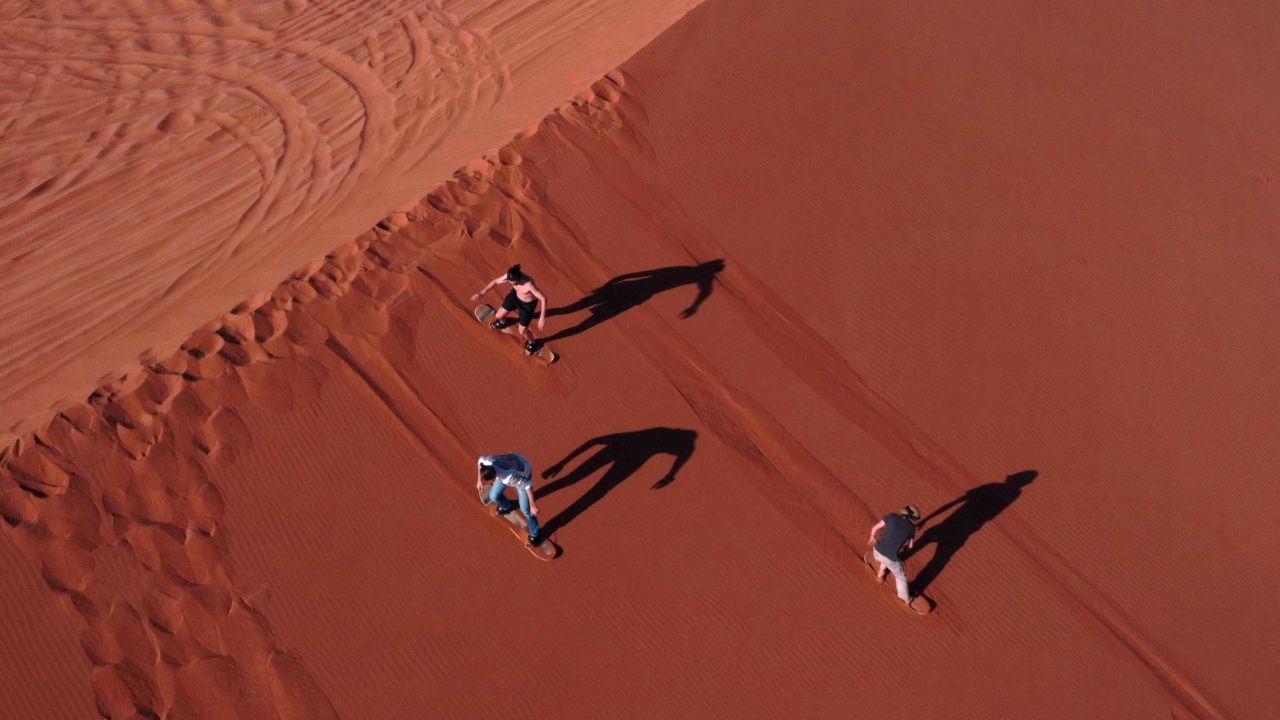 Tourists sandboarding in the Dubai desert in January. The exploits of British influencers in the city have drawn the ire of UK tabloids.