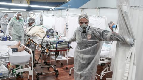SANTO ANDRE, BRAZIL - MARCH 11: Medical staff members transport a patient on a stretcher at the Pedro DellAntonia Sports Complex field hospital as coronavirus cases soar on March 11, 2021 in Santo Andre, Brazil. The state of Sao Paulo has reached over 80% occupancy in intensive care units and has declared a red alert as the spread of COVID-19 has accelerated in Brazil in recent weeks. State Health Minister Jean Gorinchteyn announced that they are already recruiting health professionals for reinforcement and working in 140 extra ICUs to prevent the collapse of the health system. 38 patients with COVID-19 have already died on the waiting list for ICU's beds in the state in the first ten days of March. (Photo by Alexandre Schneider/Getty Images)