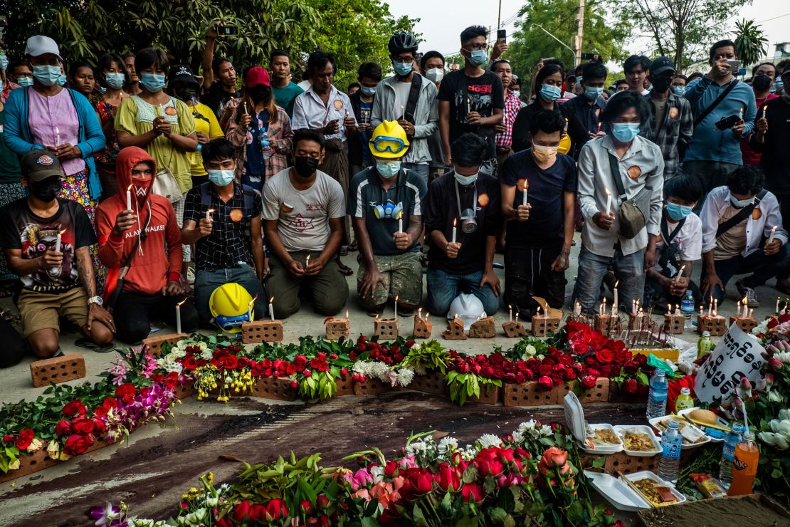 People pay tribute by laying flowers and lighting candles next to dried blood at the spot where Chit Min Thu was killed in clashes on March 11 in Yangon, Myanmar. 