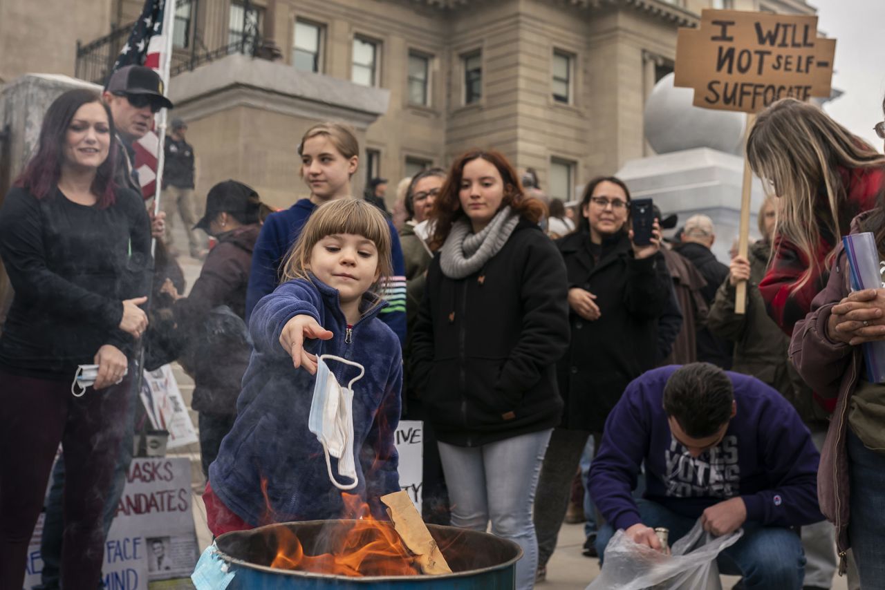 A child tosses a surgical mask into a fire during a mask-burning event at the Idaho Statehouse in Boise on March 6. People gathered in at least 20 cities across the state <a href="index.php?page=&url=https%3A%2F%2Fwww.cnn.com%2Fvideos%2Fpolitics%2F2021%2F03%2F09%2Fburn-the-mask-rallies-idaho-lauren-mclean-sot-ebof-vpx.cnn" target="_blank">to protest Covid-19 restrictions. </a>