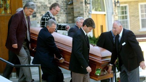 The pallbearers carry the coffin of Canadian golf legend Norman.