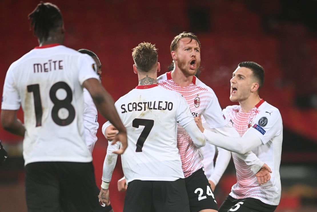 Kjaer celebrates with teammates Samu Castillejo and Diogo Dalot after scoring their team's goal against Manchester United.
