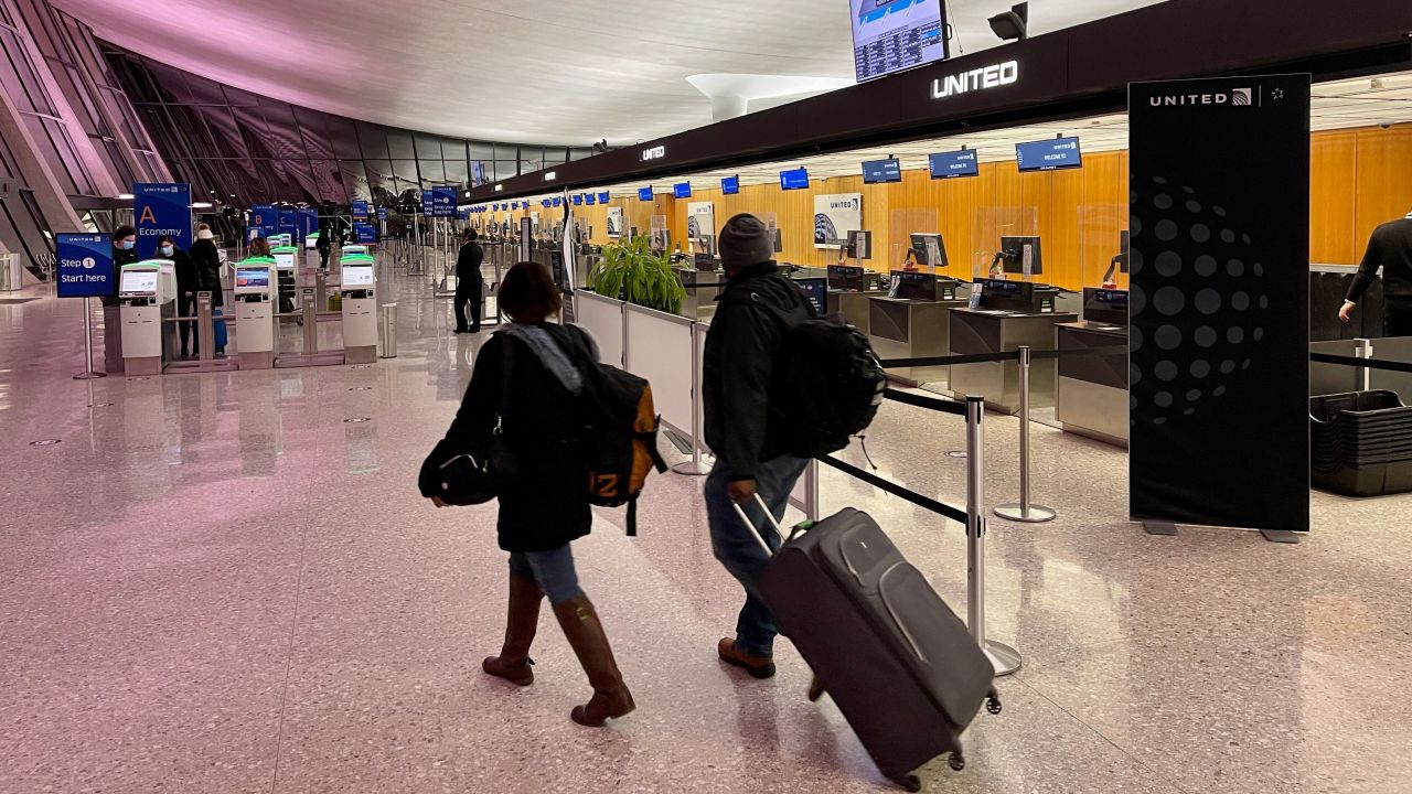 Travelers walk past a United Airlines counter at Washington's Dulles International Airport in Dulles, Virginia, on March 2, 2021 (Photo by Daniel SLIM / AFP) (Photo by DANIEL SLIM/AFP via Getty Images)