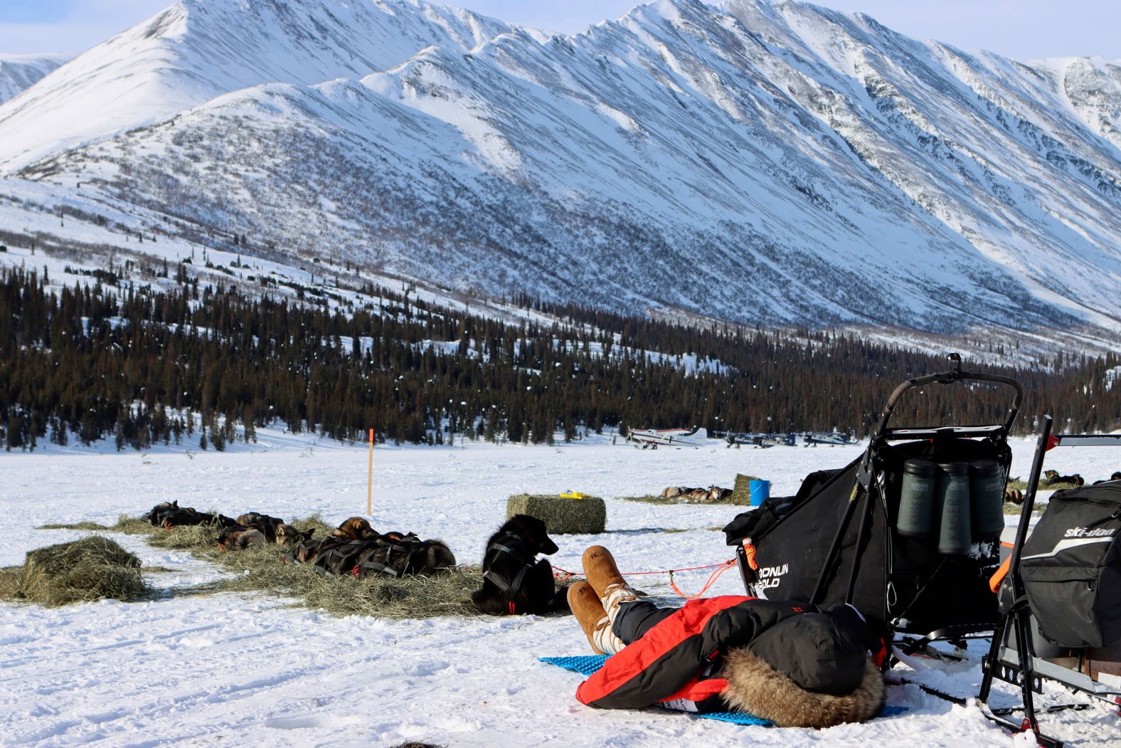 Pete Kaiser naps under his coat during a stop at the Rainy Pass checkpoint.