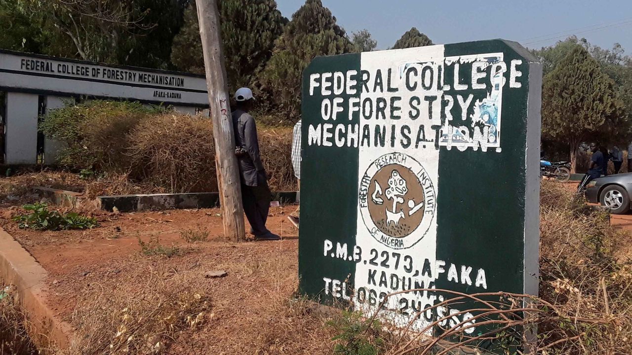 A man rests on a pole beside the signage of the Federal College of Forestry Mechanization where gunmen abducted students, in Kaduna, Nigeria March 12, 2021. REUTERS/Stringer NO RESALES. NO ARCHIVES