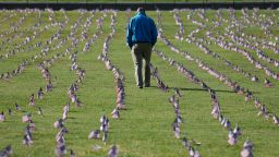 WASHINGTON, DC - SEPTEMBER 22: Chris Duncan, whose 75 year old mother Constance died from COVID on her birthday, walks through a COVID Memorial Project installation of 20,000 American flags on the National Mall as the United States crosses the 200,000 lives lost in the COVID-19 pandemic September 22, 2020 in Washington, DC. The flags are displayed on the grounds of the Washington Monument facing the White House. (Photo by Win McNamee/Getty Images)