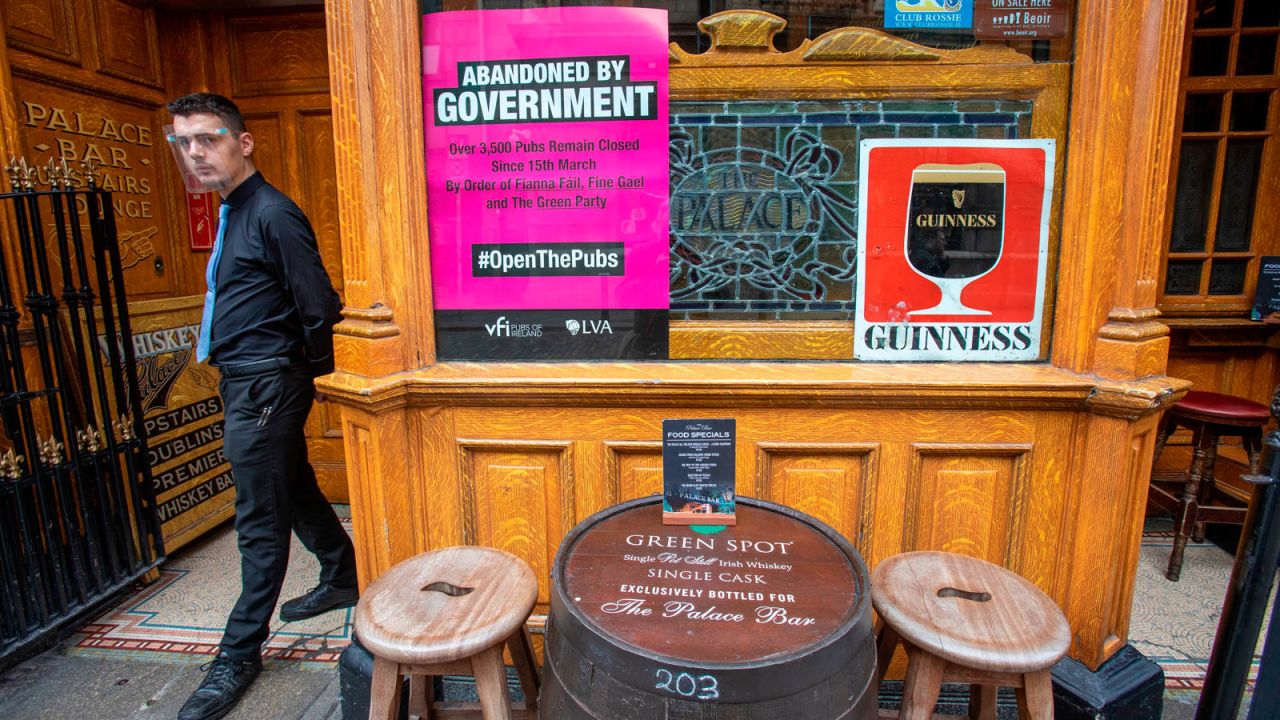 An employee wearing a face visor waits to serve customers at the Palace Bar in Dublin in September, 2020, before pubs were locked down again.