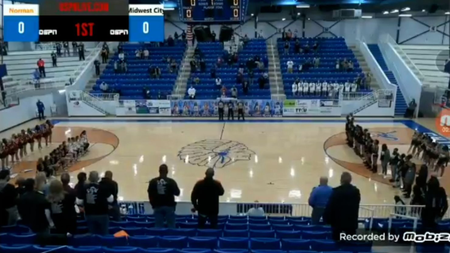 A screenshot of video streamed by the NFHS network shows the Norman High School girls basketball team kneeling during the National Anthem before a playoff game in Oklahoma. An announcer for the online broadcast made racist comments about the team as they players kneeled. 