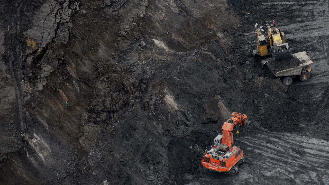 A large excavator loads a truck with oil sands at the Suncor mine in Alberta in 2009.