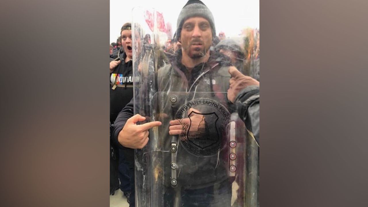 Thomas Sibick posted this photo of himself holding a police shield on Facebook, according to court filings.