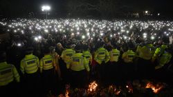 Police officers form a cordon as well-wishers turn on their phone torches as they gather at a band-stand where a planned vigil in honour of murder victim Sarah Everard was cancelled after police outlawed it due to Covid-19 restrictions, on Clapham Common, south London on March 13, 2021, - The police officer charged with murdering  young Londoner, Sarah Everard, who disappeared while walking home from a friend's house, appeared in court on March 13, 2021, as organisers cancelled a vigil in her honour due to coronavirus restrictions. (Photo by JUSTIN TALLIS / AFP) (Photo by JUSTIN TALLIS/AFP via Getty Images)