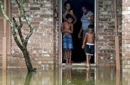 Eight-year-old Cam'ron Maltie, left, and Adrian Murray, 4, look at their flooded front lawn during Tropical Storm Beta, Tuesday, September 22, 2020, in Houston.