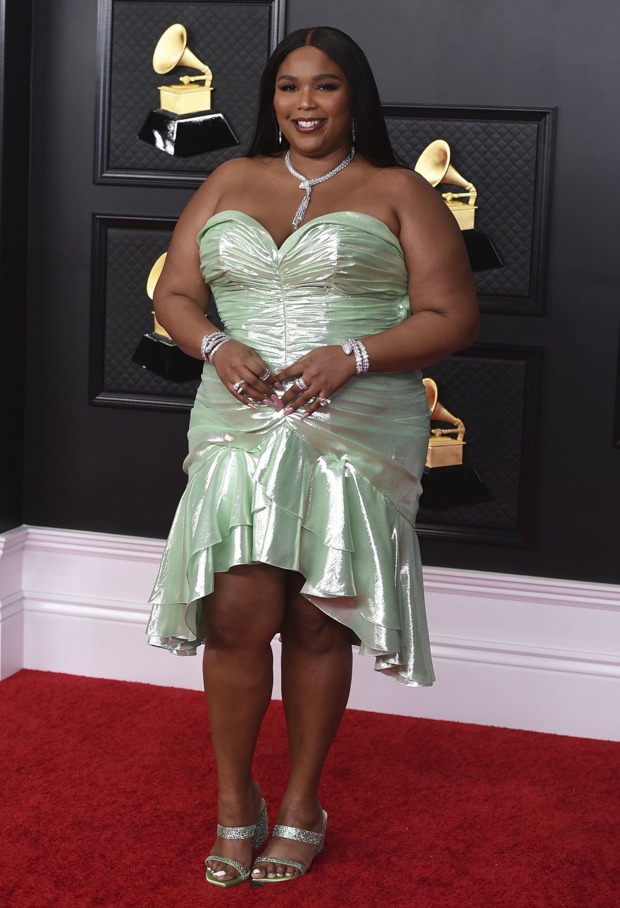 Lizzo, one of this year's Grammy Awards presenters, poses in a strapless figure-hugging gown. 