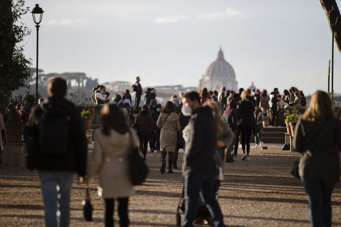 People walk in central Rome, Italy, on March 14, 2021, a day before stricter coronavirus measures came into force.