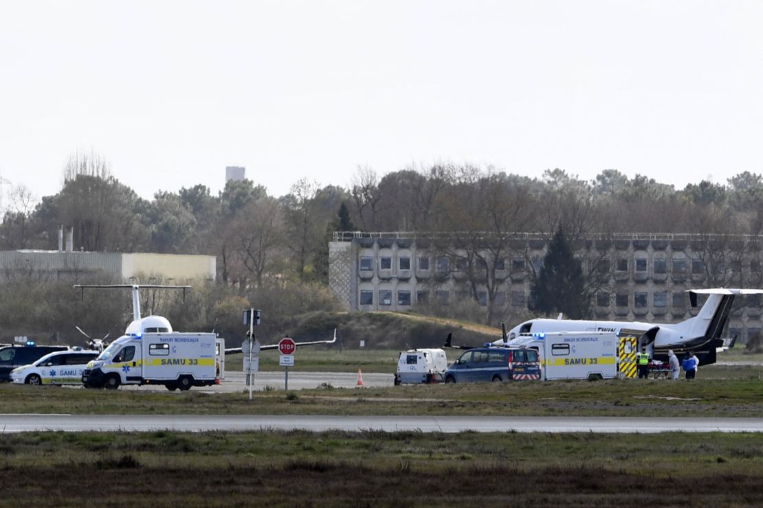 A Covid-19 patient is carried into an ambulance at a Paris airport on Sunday, ahead of their transfer to a hospital in another region.