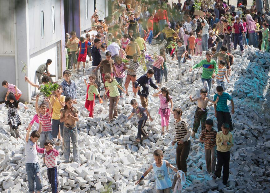 Syrian children walk over bricks stored for road repairs during a spontaneous protest June 15, 2011, at a refugee camp near the Syrian border in Yayladagi, Turkey.