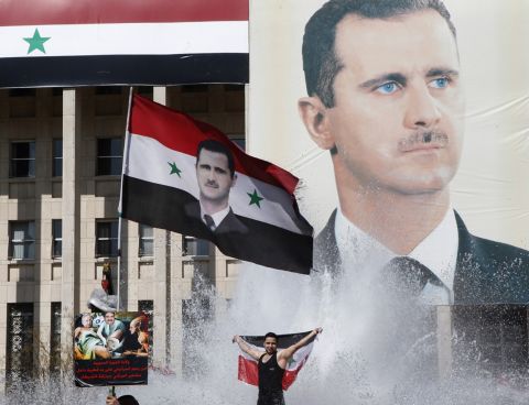 Supporters of al-Assad celebrate during a referendum vote in Damascus on February 26, 2012. Opposition activists reported at least 55 deaths across the country as Syrians headed to the polls. Analysts and protesters widely described the constitutional referendum as a farce. 
