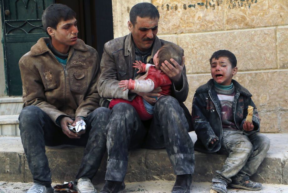 A man holds a baby who was rescued from rubble after an airstrike in Aleppo on February 14, 2014.