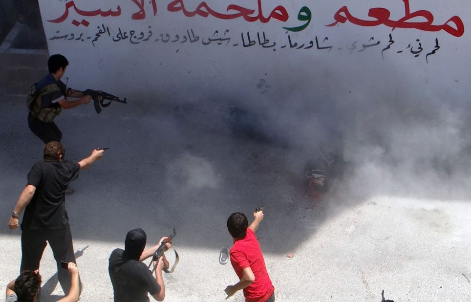 Rebel fighters execute two men on July 25, 2014, in Binnish, Syria. The men were reportedly charged by an Islamic religious court with detonating several car bombs.