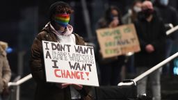 CARDIFF, WALES - MARCH 13: A woman wearing a rainbow face mask holds a sign calling for change during a vigil held in memory of murdered Sarah Everard on March 13, 2021 in Cardiff, United Kingdom.  Vigils are being held across the United Kingdom in memory of Sarah Everard. Yesterday, the Police confirmed that the remains of Ms Everard were found in a woodland area in Ashford, a week after she went missing as she walked home from visiting a friend in Clapham. Metropolitan Police Officer Wayne Couzens has been charged with her kidnap and murder. (Photo by Polly Thomas/Getty Images)