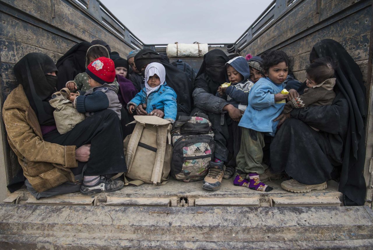 Women and children who fled the Islamic State group's embattled holdout of Baghouz wait in the back of a truck in the eastern Syrian province of Deir Ezzor, on February 14, 2019.