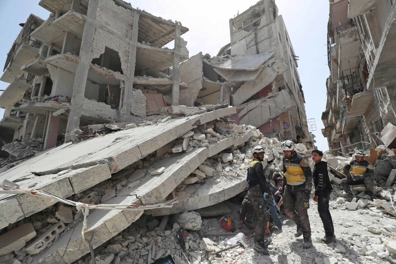 Members of the Syrian Civil Defence, also known as the "White Helmets," search the rubble of a collapsed building following an explosion in the town of Jisr al-Shughur on April 24, 2019.