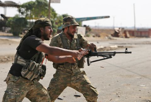 Turkish-backed Syrian fighters take part in a battle in Syria's northeastern town of Ras al-Ain as Turkey and its allies continue their assault on Kurdish-held border towns in northeastern Syria on October 14, 2019.