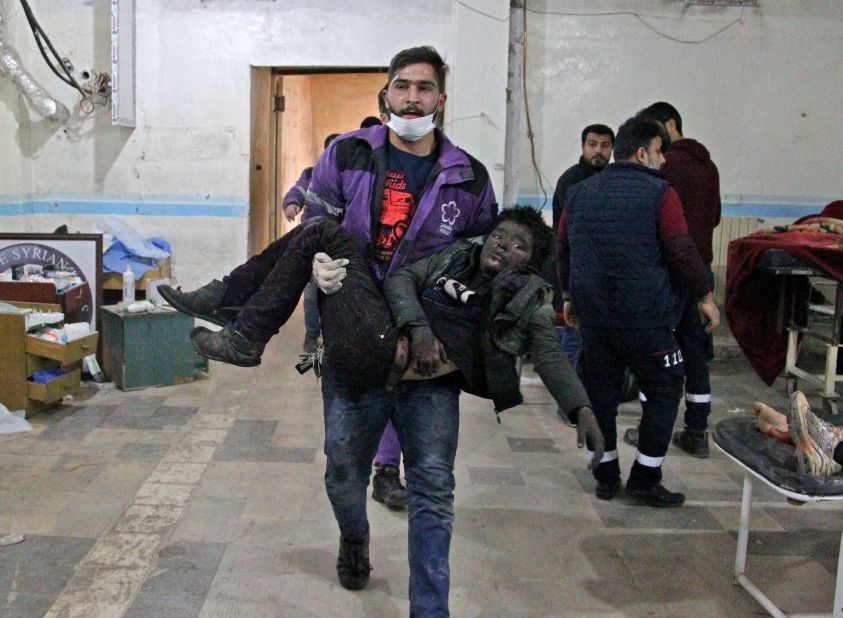 A member of the Syrian Violet Organization carries an injured boy at a makeshift hospital following a regime air strike on a vegetable market in Syria's last major opposition bastion of Idlib on January 15, 2020.