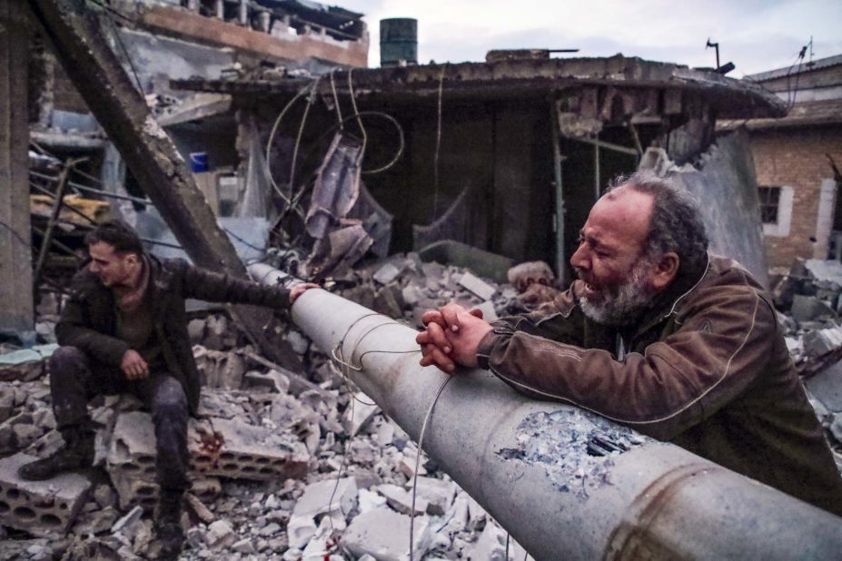 A Syrian man mourns the death of family members next to the rubble of his house following a reported airstrike on the village of Kafr Nuran, in the northern province of Aleppo, on January 21, 2020.