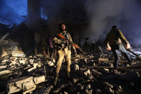 Members of Syrian Civil Defence and Turkish-backed Syrian forces search for victims in the aftermath of a car bomb explosion near a security checkpoint in the town of Azaz on March 19, 2020.