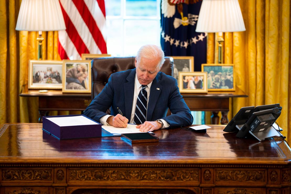 President Joe Biden signs  the $1.9 trillion Covid relief bill into law in the Oval Office of the White House on Thursday, March 11, in Washington