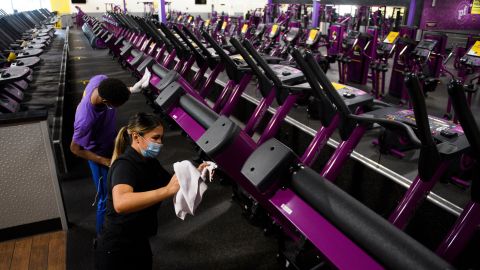 A Planet Fitness Inc. employee cleans gym equipment before the location's reopening after being closed due to Covid-19 on March 15, 2021 in Inglewood, California.