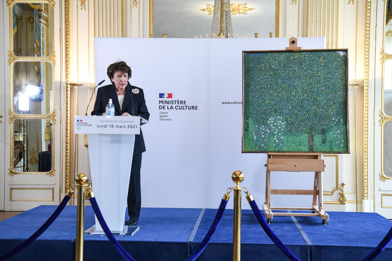 French Culture Minister Roselyne Bachelot stands next to a Nazi-pillaged artwork, Gustav Klimt's "Rosebushes under the Trees" (1905), in March 2021.
