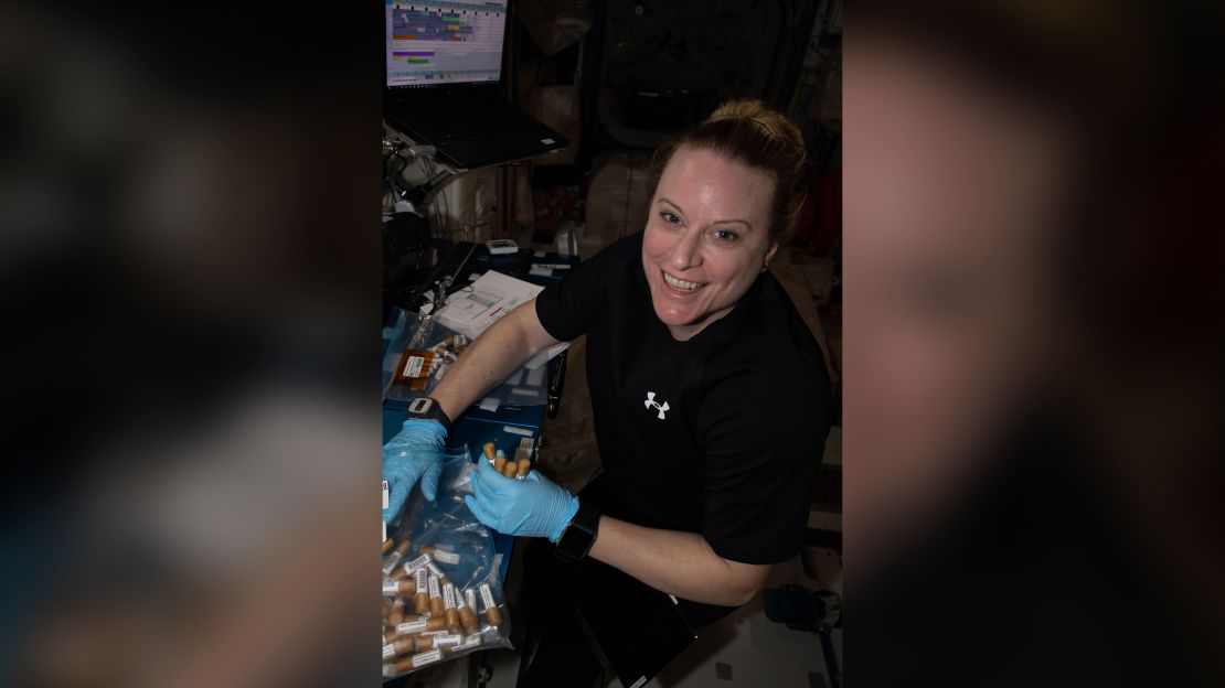 NASA astronaut Kate Rubins collects tubes containing swab samples of microbes on the space station.