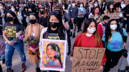 Demonstrators wearing face masks and holding signs take part in a rally "Love Our Communities: Build Collective Power" to raise awareness of anti-Asian violence, at the Japanese American National Museum in Little Tokyo in Los Angeles, California, on March 13, 2021. 
