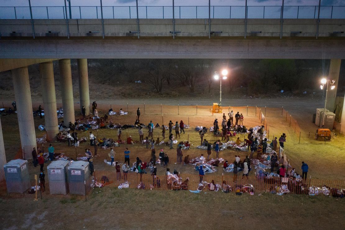 Asylum seeking migrant families and unaccompanied minors from Central America take refuge in a makeshift U.S. Customs and Border Protection processing center under the Anzalduas International Bridge after crossing the Rio Grande river into the United States from Mexico in Granjeno, Texas, U.S., March 12, 2021. 