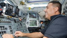 Former astronaut José Hernández working controls on the flight deck of space shuttle Discovery while docked with the International Space Station on August 31, 2009.