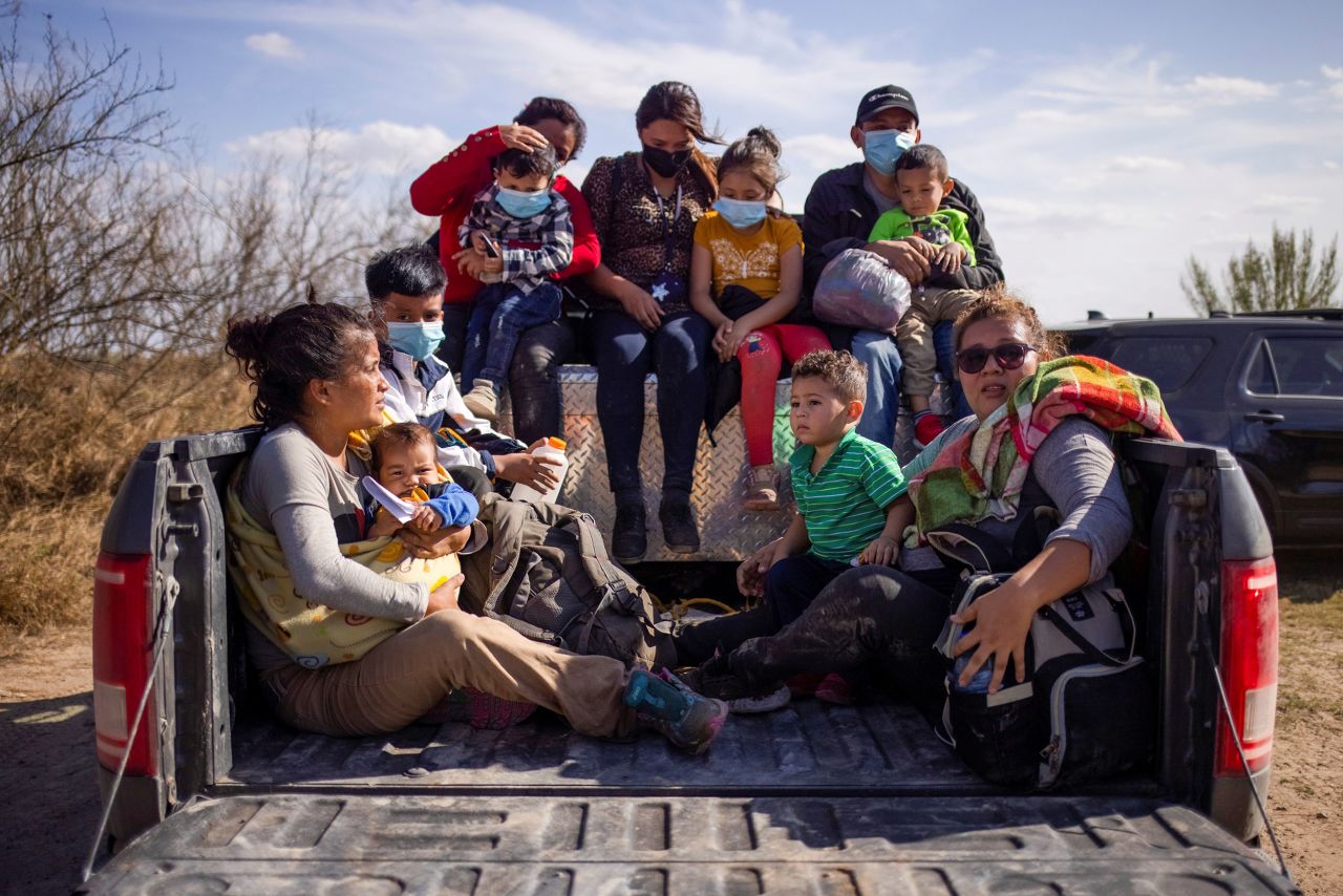 Migrant families and children sit in the back of a police truck after they crossed the Rio Grande on March 5.