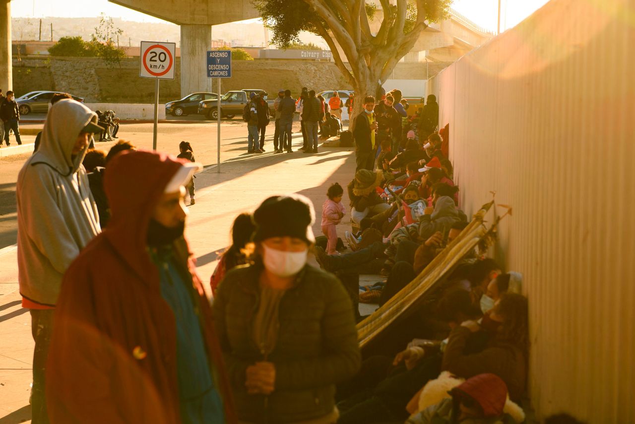 Asylum seekers wait outside the El Chaparral border crossing port as they wait to cross into the United States from Tijuana on February 19. The Biden administration is still turning back most migrants at the border, but officials are gradually allowing 25,000 people previously enrolled in the Migrant Protection Protocols program to cross into the United States.