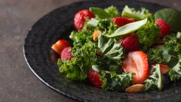 Fresh salad with strawberry, raspberry, nuts, kale and spinach.