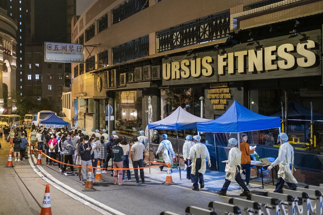 Government workers wearing personal protective equipment walk past the closed Ursus Fitness gym on Sunday.