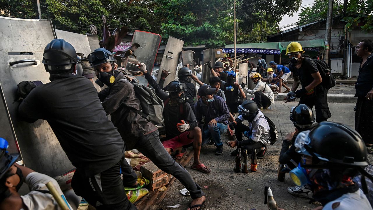 Protesters take cover behind homemade shields as they confront the police during a crackdown on demonstrations against the military coup in Yangon on March 16.