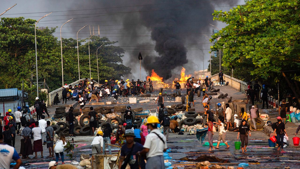 Chaotic scenes of makeshift barricades on a bridge set on fire by police during a demonstration against the military coup in Yangon.