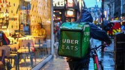 A food delivery courier working for Uber Eats, operated by Uber Technologies Inc., pushes a bicycle past a restaurant in the Soho district of London, U.K., on Friday, Oct. 2, 2020. Covid-19 lockdown enabled online and app-based grocery delivery service providers to make inroads with customers they had previously struggled to recruit, according the Consumer Radar report by BloombergNEF. Photographer: Hollie Adams/Bloomberg via Getty Images