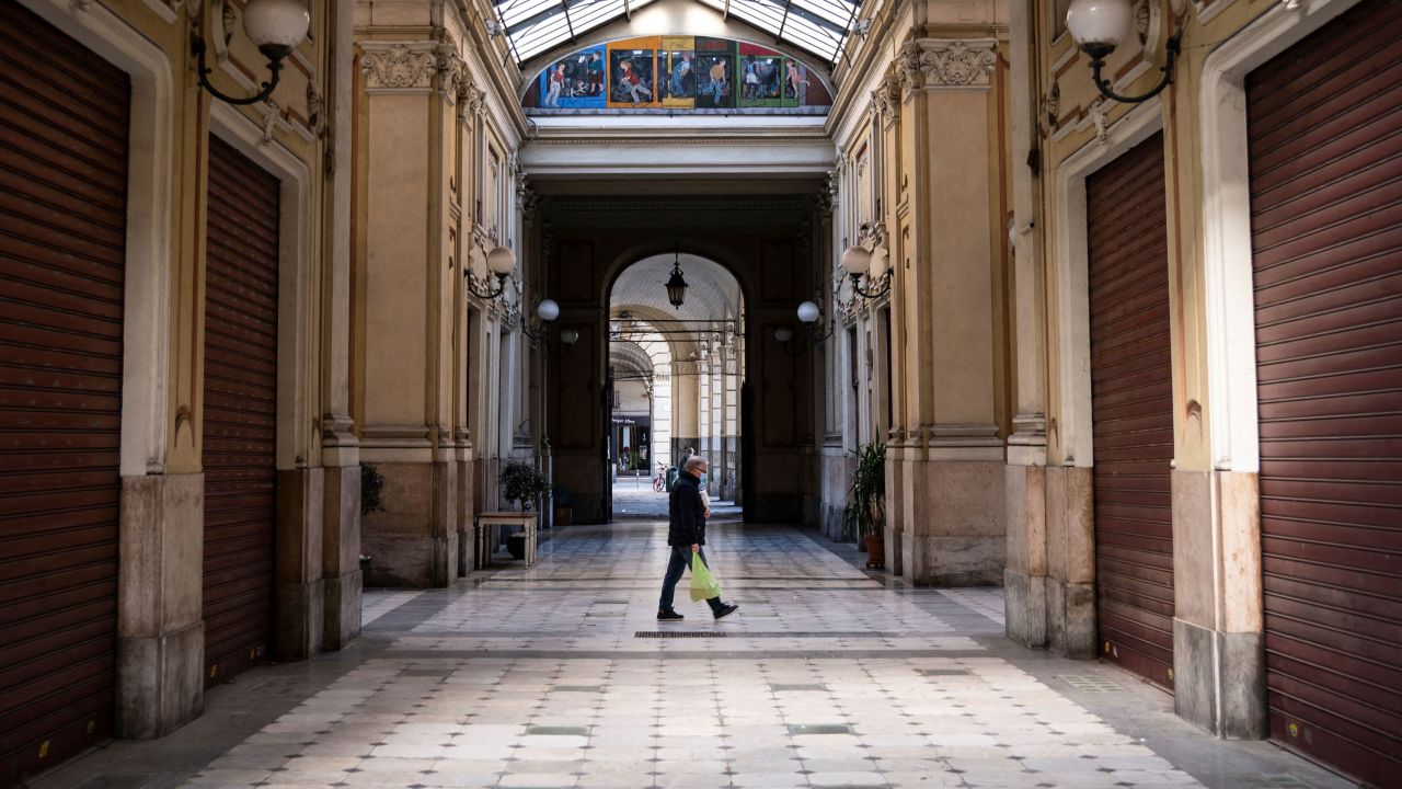 A man wearing a face mask walks across the Galleria Umberto I on March 17, 2021 in Turin during a new lockdown in response to the Covid-19 pandemic.